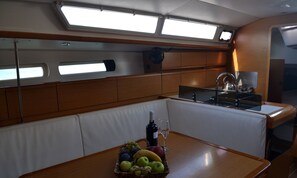A compact galley with a wooden table, a sink, and a small seating area.