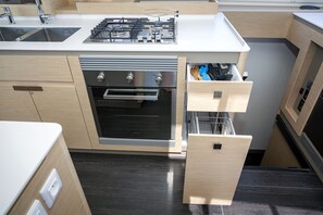 A compact kitchen with a built-in oven, a gas stove, and a drawer with utensils. - Sun-Kissed Sailing Adventure in the Ionian Islands, Lefkada (Lefkada)