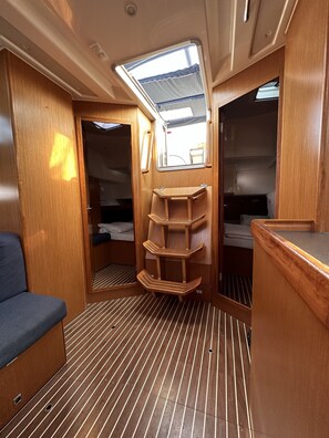 A compact interior with a bunk bed, a small seating area, and a skylight. - Sun-Kissed Sailing Adventure in Zadar, Croatia (Drage)