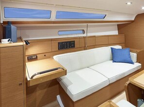 A compact cabin with a white sofa, a small table, and a control panel. - Sun-Kissed Sailing Adventure in the Ionian Islands, Lefkada (Lefkada)