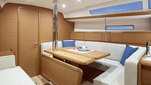 A compact boat interior with a wooden bench, a small table, and a cushioned seating area. - Sun-Kissed Sailing Adventure in the Ionian Islands, Lefkada (Lefkada)