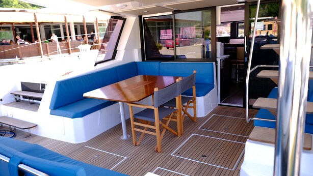 A boat interior with a dining area, seating, and a view of the outside. - Sun-Kissed Sailing Adventure in Sibenik, Croatia (Primošten)