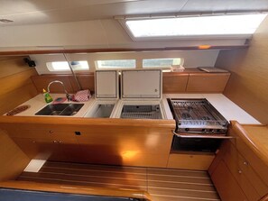 A compact galley with a sink, stove, and storage cabinets. - Sun-Kissed Sailing Adventure in Zadar, Croatia (Bibinje)
