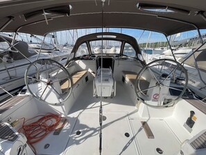 Convés de barco com dois volantes, um console central e uma rede de cordas.