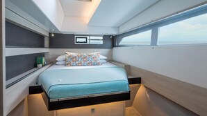 Una cabaña compacta y moderna con cama, almacenaje integrado y ventana con vistas.