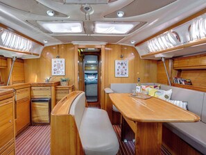 A compact interior with a kitchenette, dining area, and seating. - Sun-Kissed Sailing Adventure in the Ionian Islands, Lefkada (Lefkada)