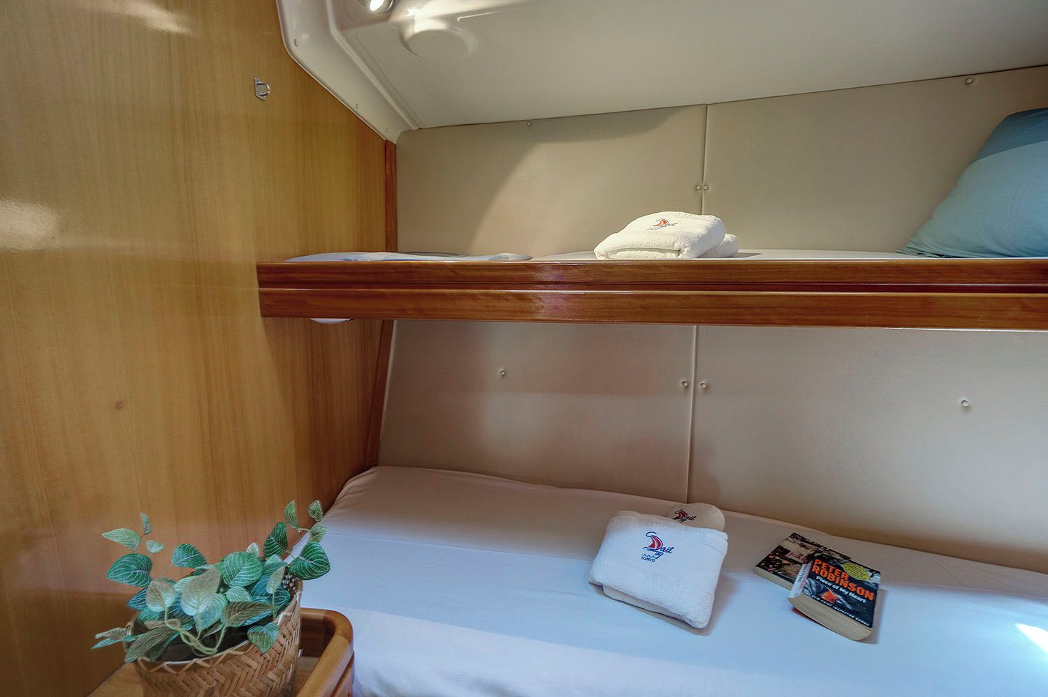 Ein Etagenbett mit weißer Matratze und einem zusammengeklappten Handtuch auf der unteren Koje.