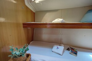 A bunk bed with a white mattress and a folded towel on the lower bunk. - Sun-Kissed Sailing Adventure in the Ionian Islands, Lefkada (Lefkada)