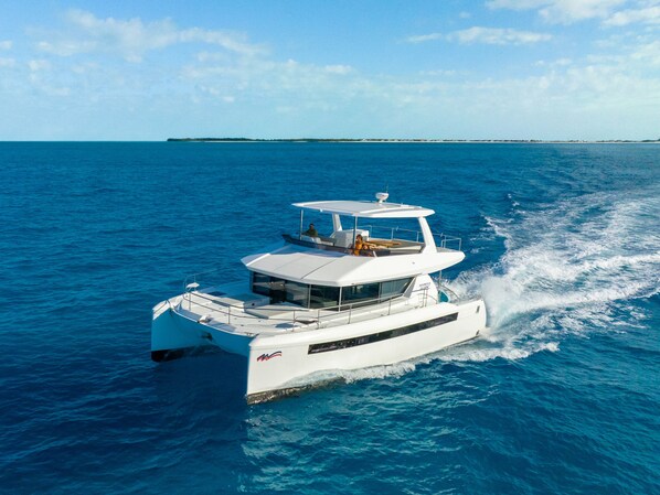 A white yacht with a cabin and a covered deck, sailing on a calm sea.