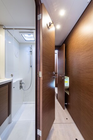 A narrow hallway with wooden walls, a shower area with a skylight, and a visible bathroom door. - Sun-Kissed Sailing Adventure in the Ionian Islands, Lefkada (Lefkada)