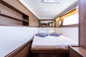A compact, well-lit interior with a bed, storage shelves, and a window. - Sun-Kissed Sailing Adventure in the Ionian Islands, Lefkada (Lefkada)