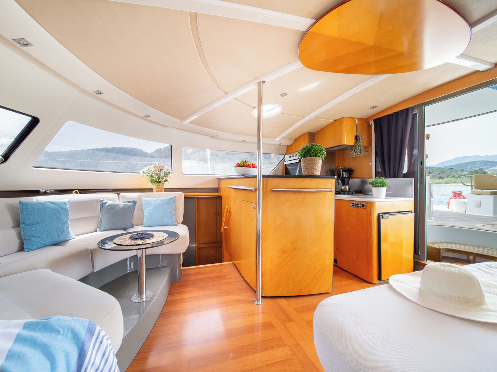 A yacht interior with a dining area, kitchen, and seating space.