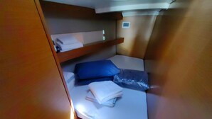 Una cabaña pequeña con una cama nido, un estante y una ventana.