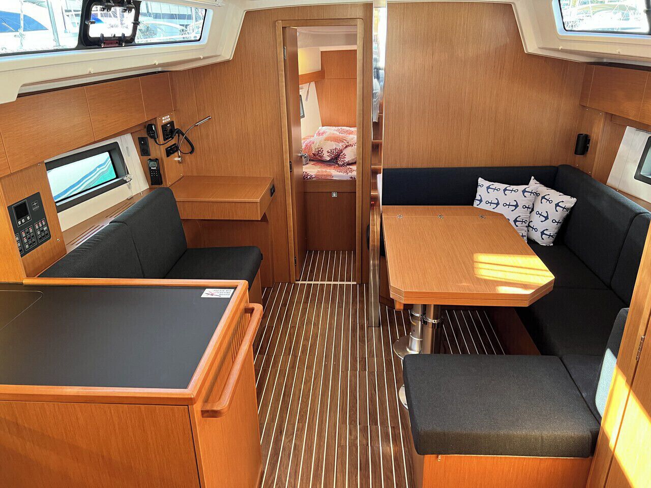 A compact interior with a dining table, seating area, and control panel.
