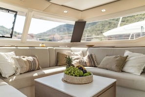Ein modernes Interieur mit einer Couch, einer gewebten Obstschale und Blick ins Freie.