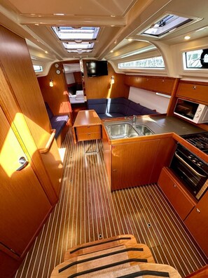 A compact galley with a sink, stove, and seating area.