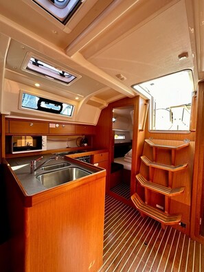 A compact galley with a stainless steel sink, a microwave, and a stove.