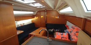 A compact interior with a kitchenette, a sink, a small table, a sofa, and a couch. - Sun-Kissed Sailing Adventure in Zadar, Croatia (Bibinje)