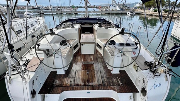 Das Deck eines Segelbootes mit blauem Sonnendach, Steuer und Armaturenbrett.