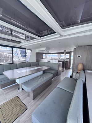 A modern interior with a central seating area, a kitchen, and large windows. - Sun-Kissed Sailing Adventure in Northern Croatia (Novi Vinodolski)