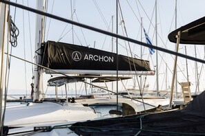 A marina with sailboats docked, a covered area with 'ARCHON' branding, and a clear sky. - Sun-Kissed Sailing Adventure in the Dodecanese Islands (Kos)