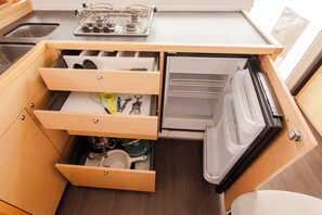 A compact kitchen with a built-in refrigerator, a sink, and a stove. - Sun-Kissed Sailing Adventure in the Ionian Islands, Lefkada (Lefkada)