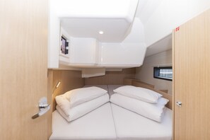 A compact cabin with a bed, a small window, and a built-in storage area.