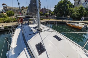 Ein Boot liegt in einem Kanal vor einer Kulisse aus Gebäuden und Grünflächen.