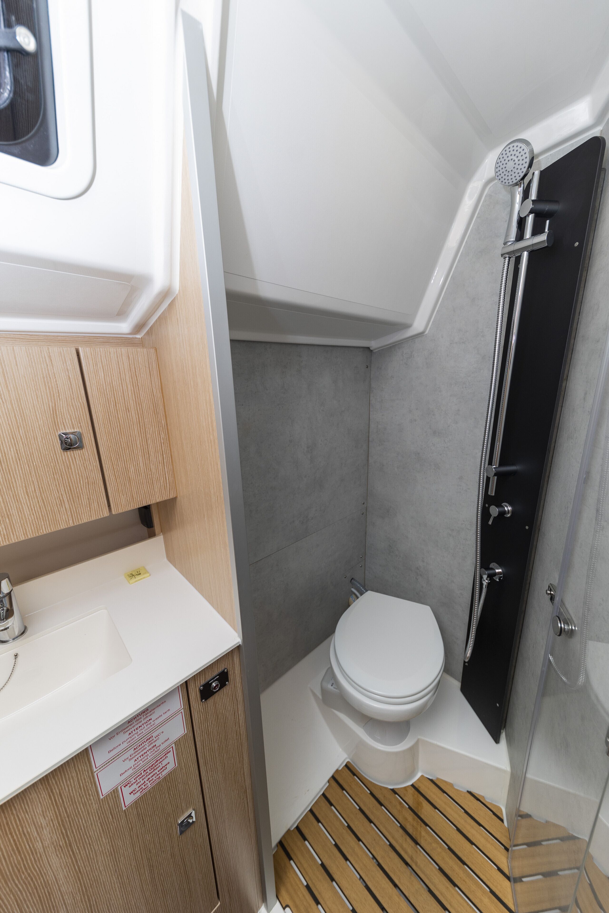 A compact bathroom with a shower, toilet, and sink.