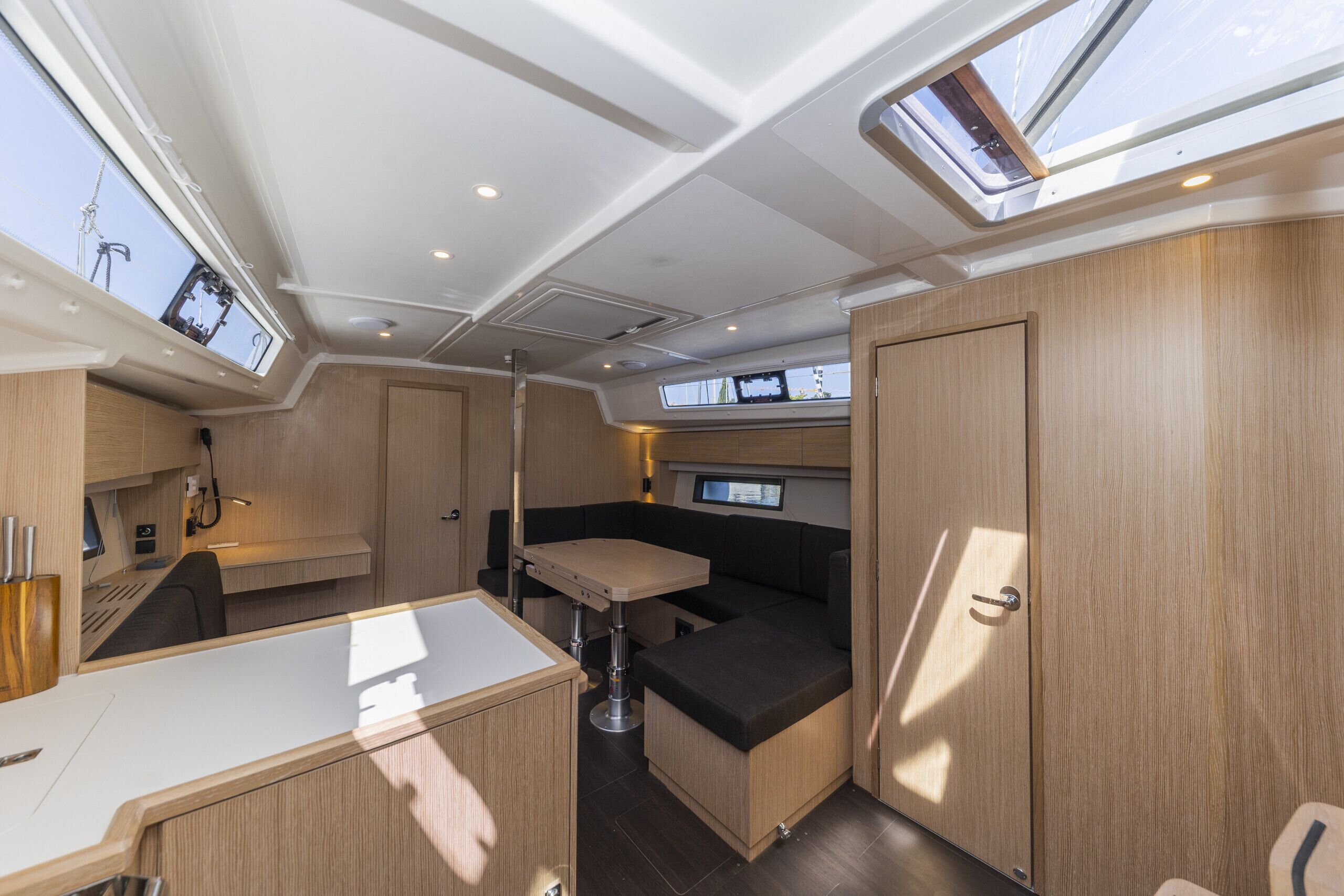 Un intérieur compact et bien éclairé, comprenant un coin repas, une petite cuisine et un espace salon.