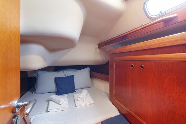 Una cabaña acogedora con cama, almohadas y toallas dobladas con cuidado.