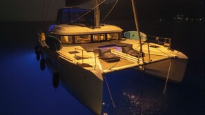 A boat with a covered deck, a cabin, and a small open area with seating.