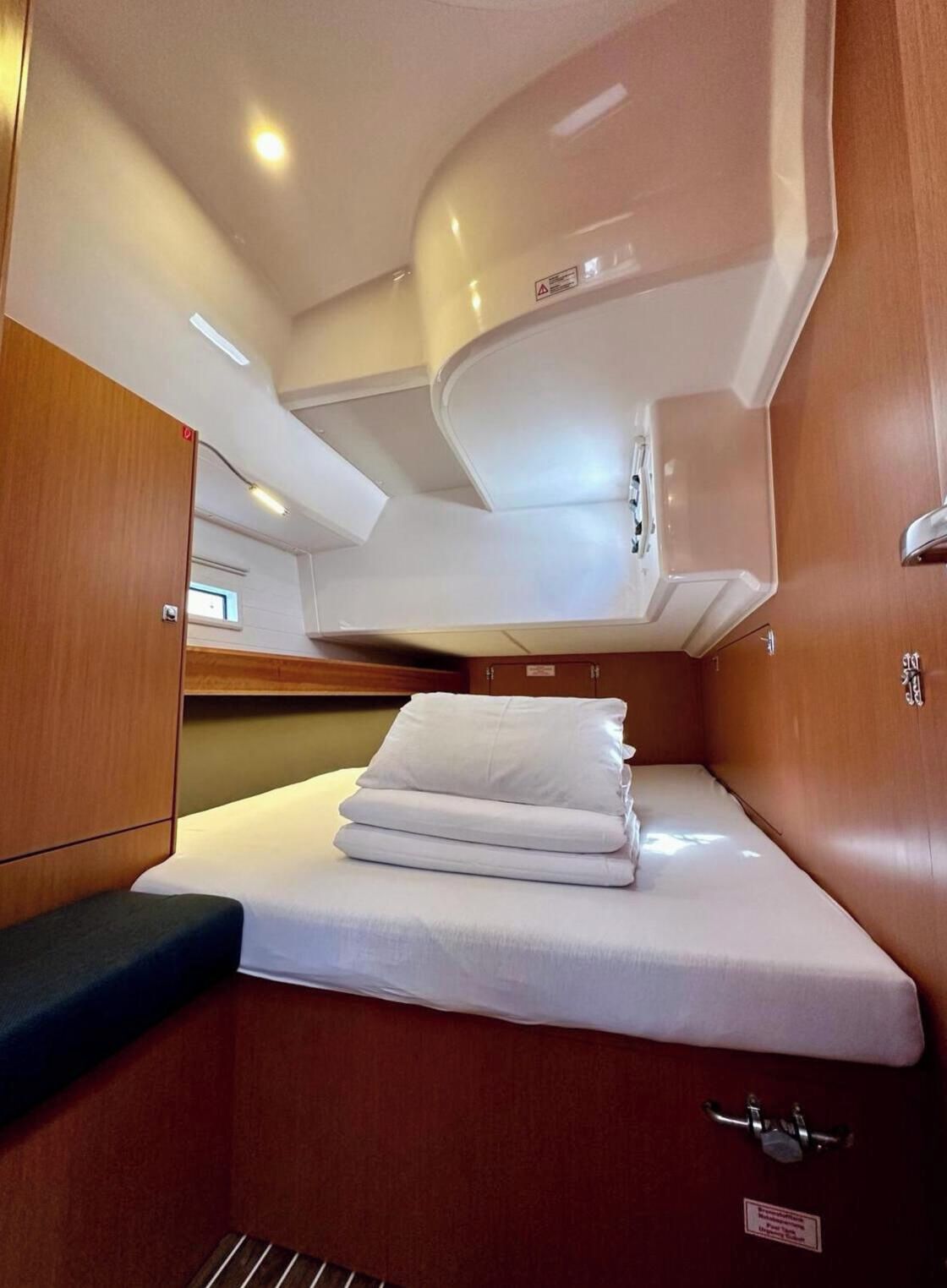 Una cabaña pequeña con una cama, una zona de estar compacta y un armario para guardar objetos.