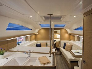 A modern interior with a central sink, seating area, and skylights.