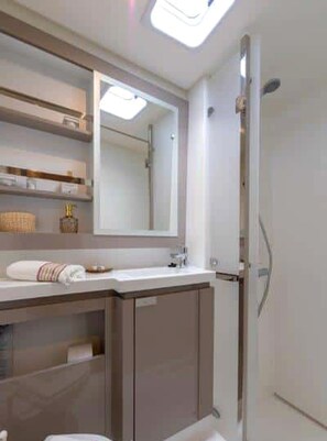 A modern bathroom with a large mirror, a shower, and a vanity with a towel rack. - Sun-Kissed Sailing Adventure in Islas Baleares, Mallorca (Palma)