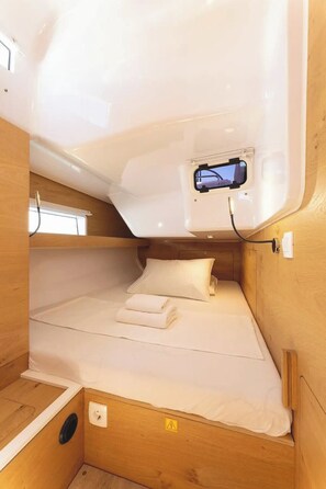 A compact cabin with a bunk bed, a small window, and a power outlet. - Sun-Kissed Sailing Adventure in Zadar, Croatia (Zadar)