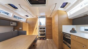 Una cocina compacta con armarios de madera, un comedor con mesa y un horno empotrado.