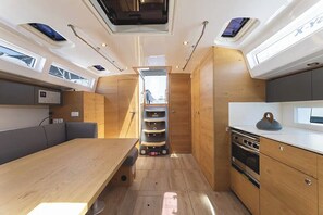 A compact kitchen with wooden cabinets, a dining area with a table, and a built-in oven.