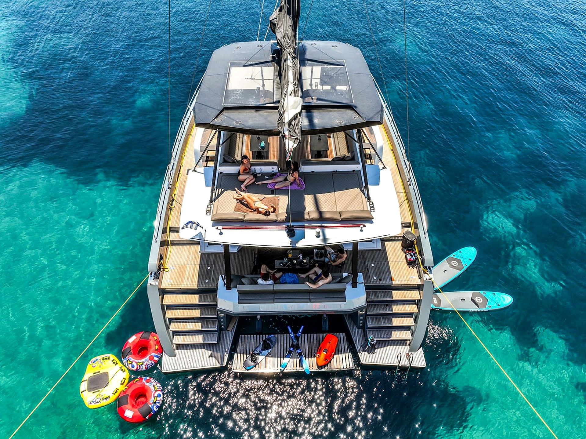 A yacht with a deck area, seating, and a small boat docked at the stern.