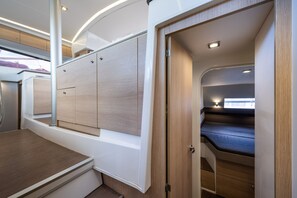 Ein kompakter Innenraum mit Bett, Einbauschränken und einer kleinen Sitzecke.