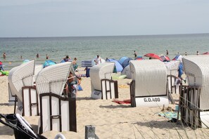 Beach huts with numbers, a sandy beach, and the sea in the background. - Apartment mit Strandkorb in Uckeritz (Ueckeritz)