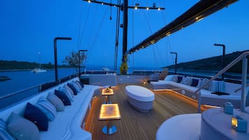 Un pont de yacht doté d’un espace salon, d’une table et d’une vue sur l’eau.