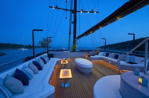 A yacht deck with a seating area, a table, and a view of the water. - Sun-Kissed Sailing Adventure in Split, Croatia (Split)