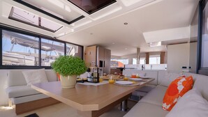 Un interior moderno con zona de comedor, asientos y vista al puerto deportivo.