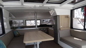 En stilren och modern inredning med ett centralt placerat bord, sittgrupper och stora fönster med fin utsikt.