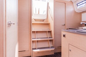 Eine kleine Küche mit Holzschränken, einer eingebauten Ablage und einem Fenster über der Spüle.