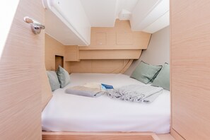A compact, well-lit cabin with a bunk bed, a small bedside table, and a neatly made bed with a blanket and pillow. - Sun-Kissed Sailing Adventure in the Ionian Islands, Lefkada (Lefkada)