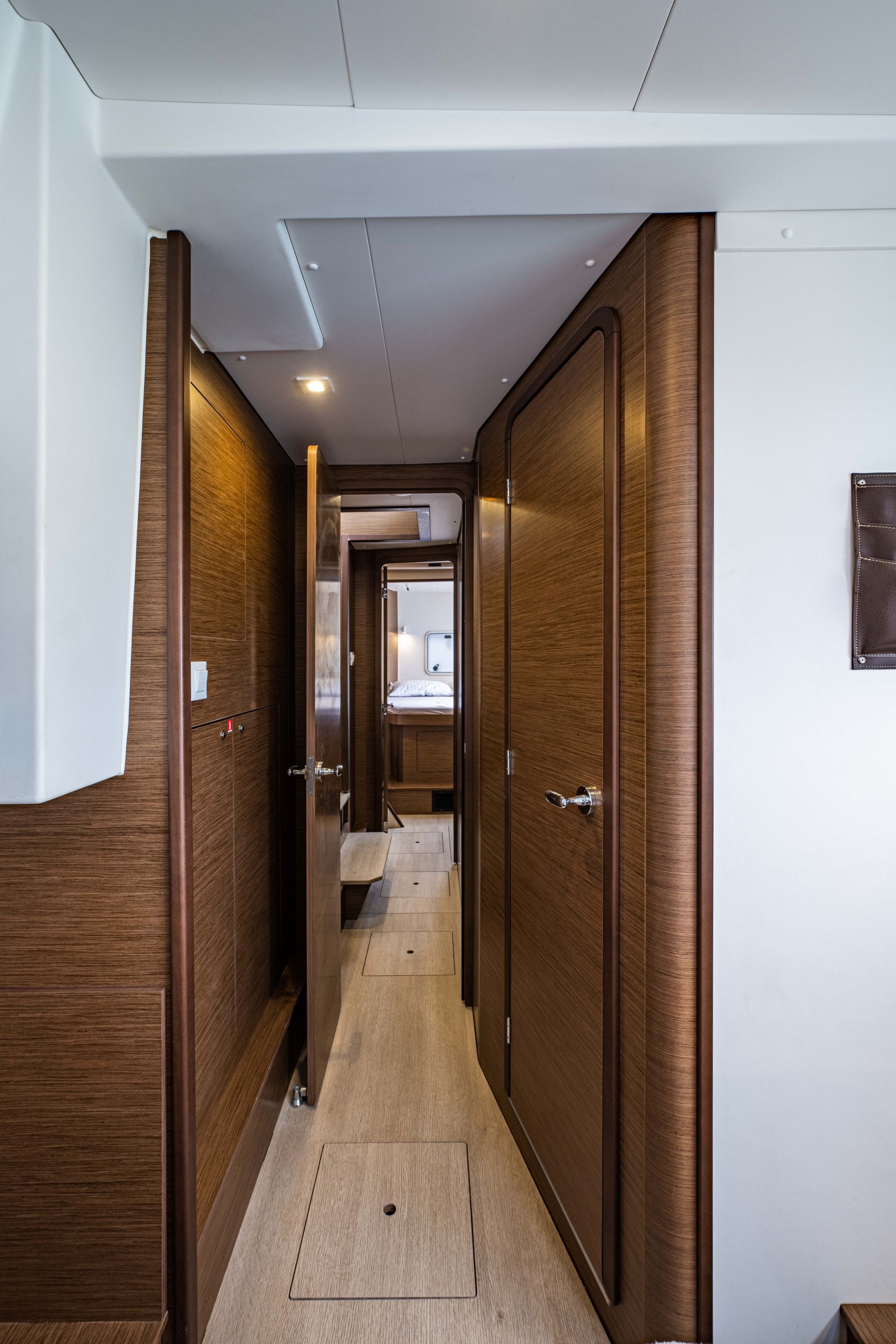 A narrow hallway with wooden doors and a small bench.