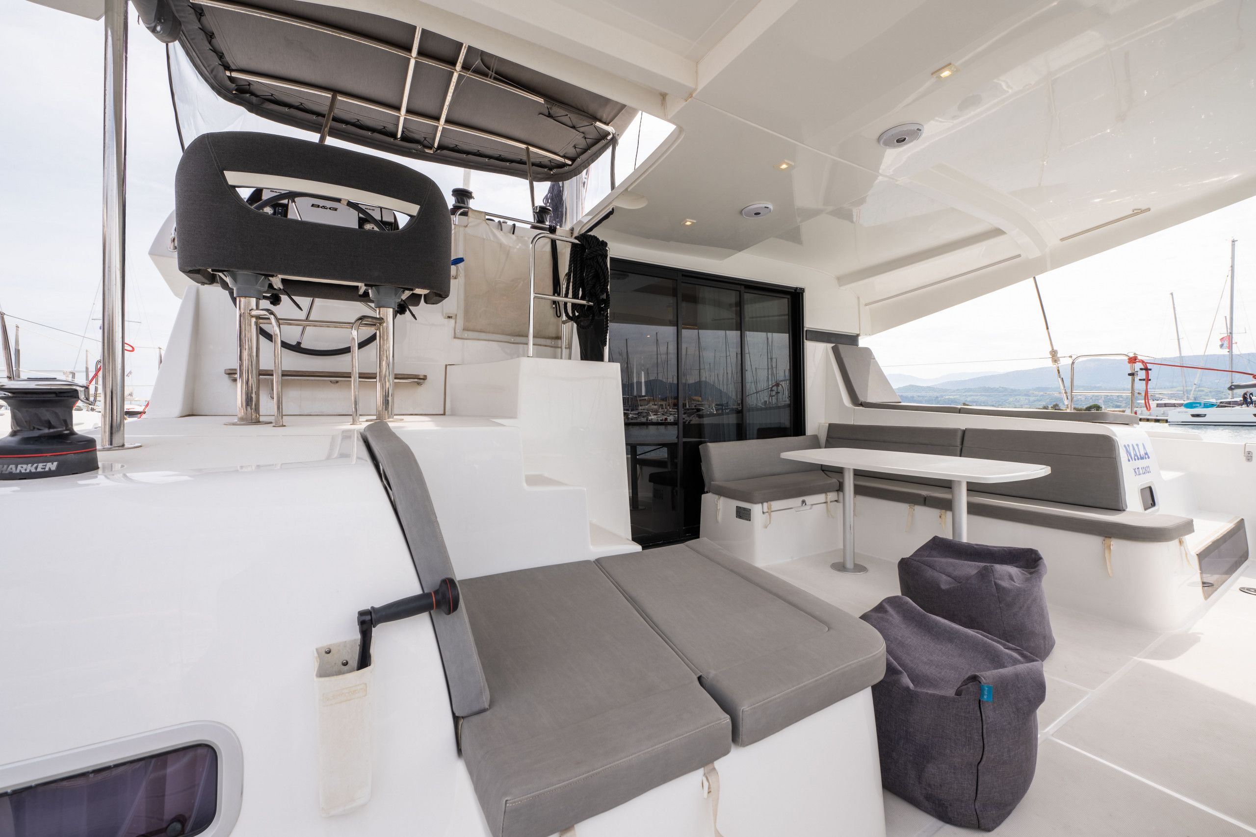 Ein Yachthausdeck mit Sitzgelegenheit, einem Tisch und Blick aufs Meer.