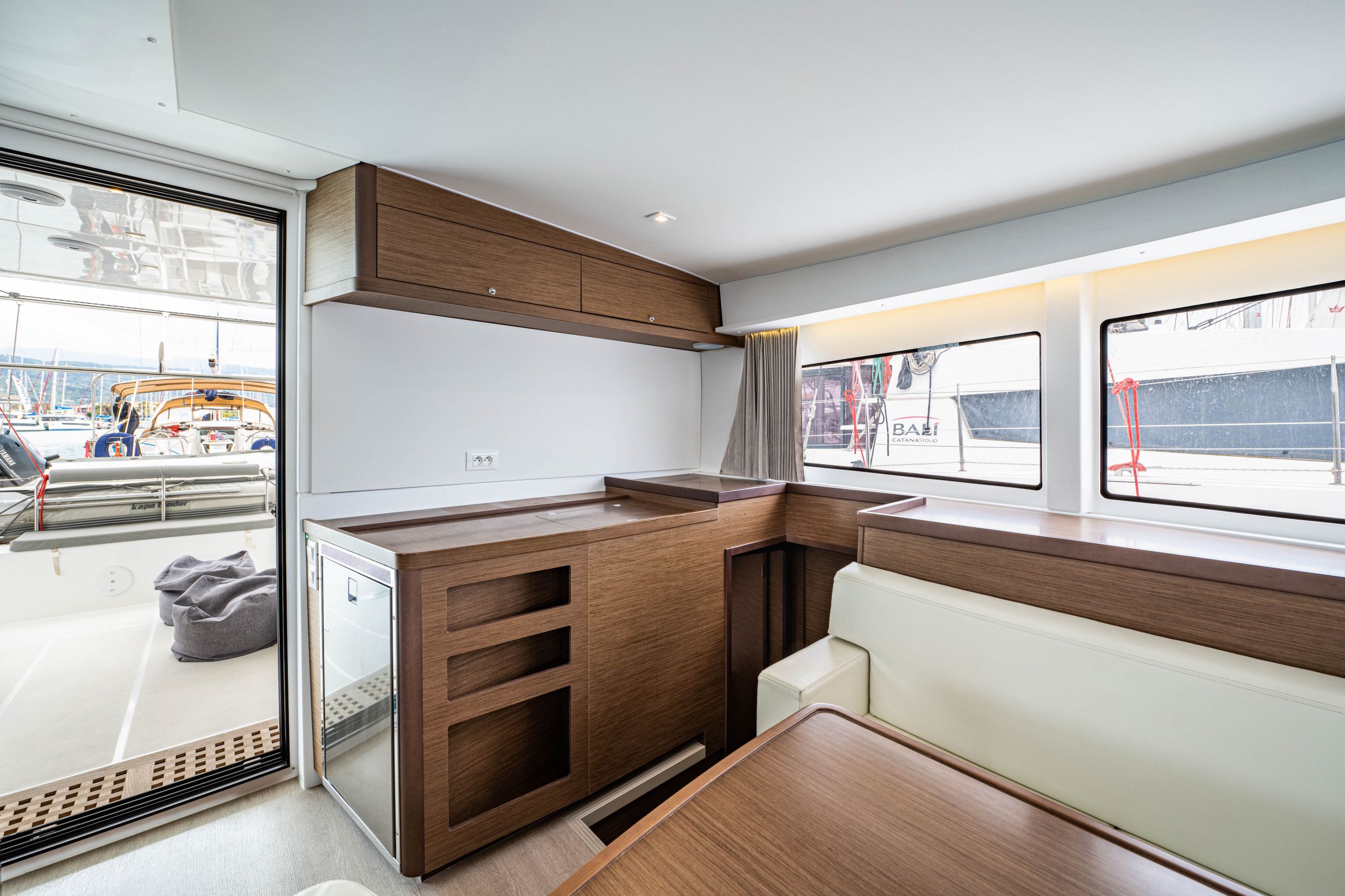 Une cuisine compacte avec des meubles en bois, un banc intégré et une fenêtre donnant sur l’extérieur.